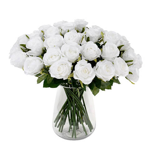 bouquet of white artificial roses in clear glass vase