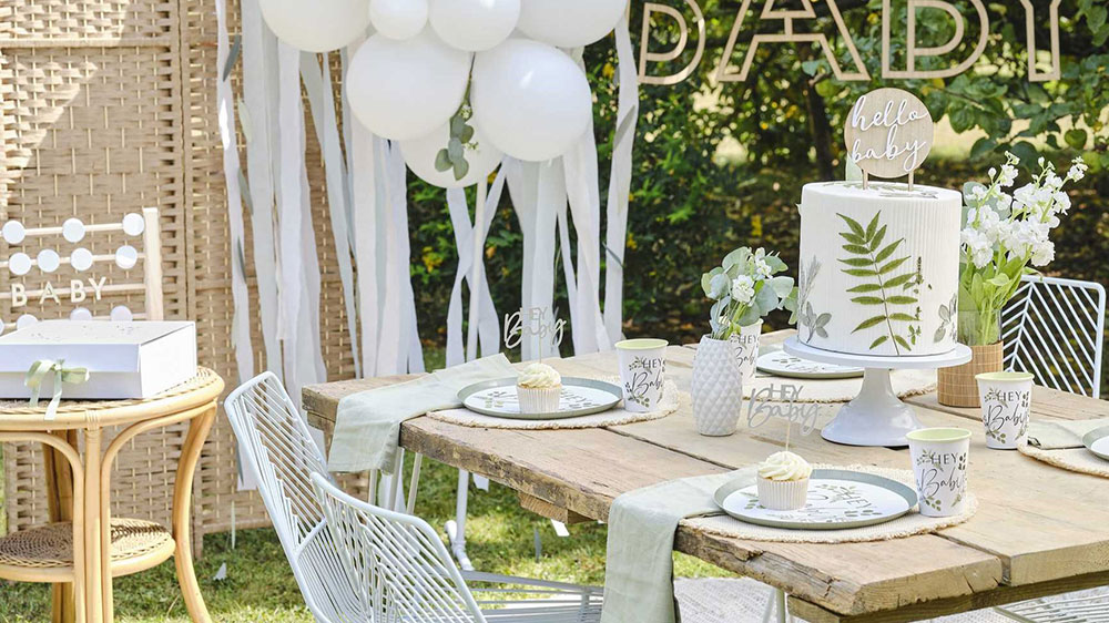 baby shower decoration ideas - party table outside with cake and botanical theme in green and white