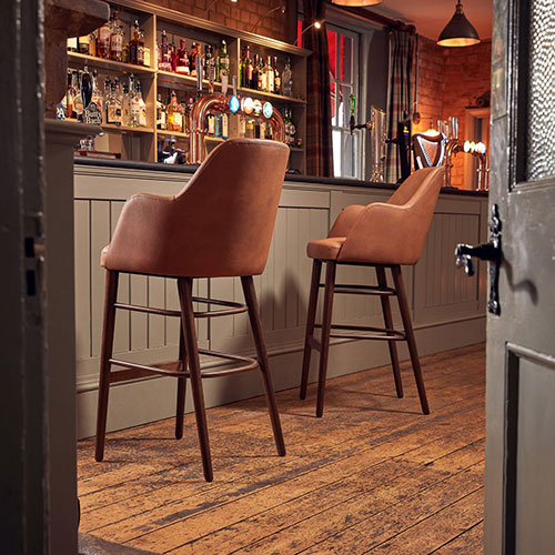 two luxury tan contract bar stools in front of a grey bar