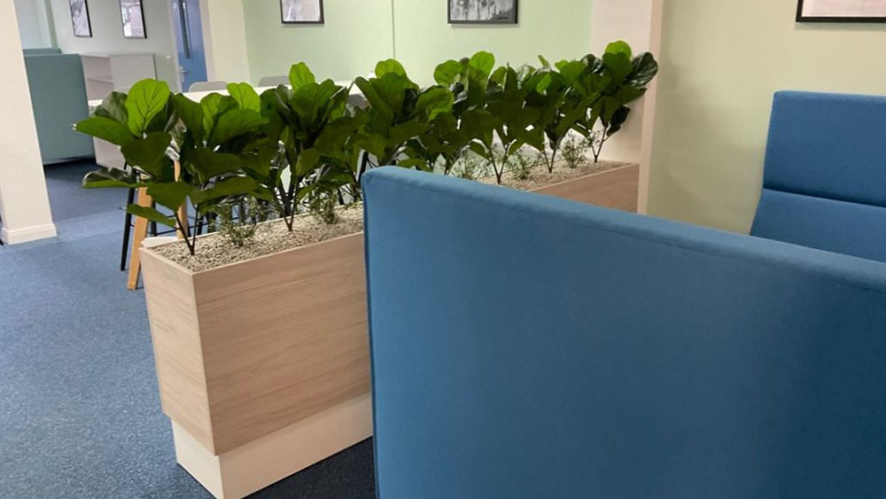 seating area with long divider of faux office plants