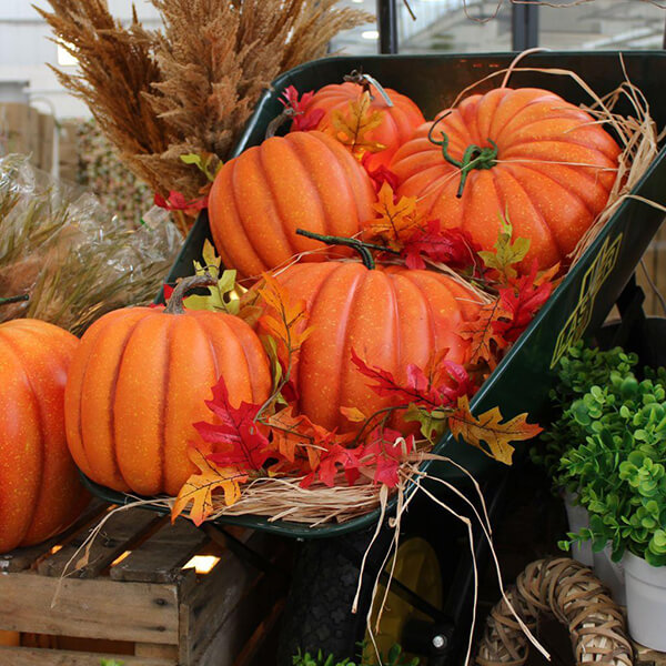 artificial pumpkins in wheelbarrow autumn decorations
