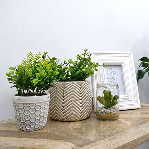 artificial potted plants on table with white frame