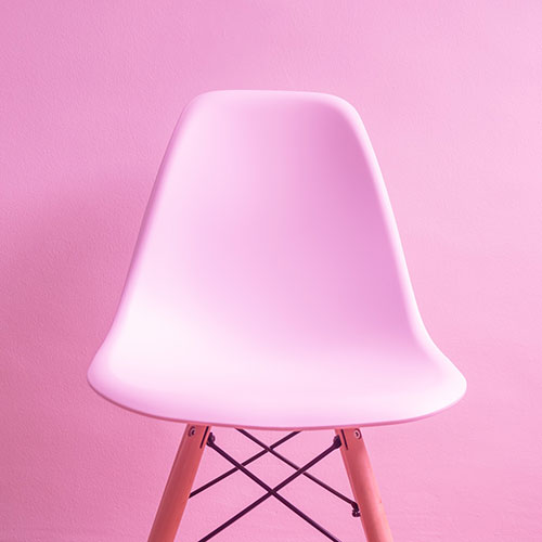 pink rounded chair with pink wall