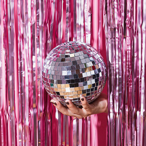pink foil curtain with silver disco ball in hand