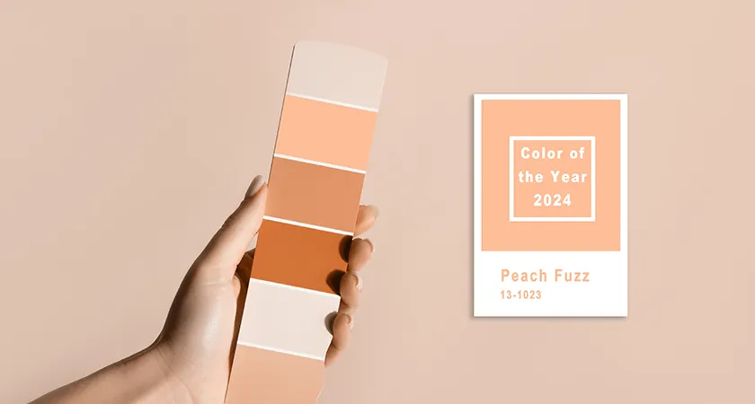 hand holding colour samples with pantone colour of the year 2024 peach fuzz