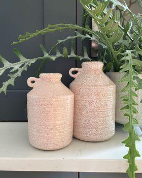 peach vases next to artificial plants