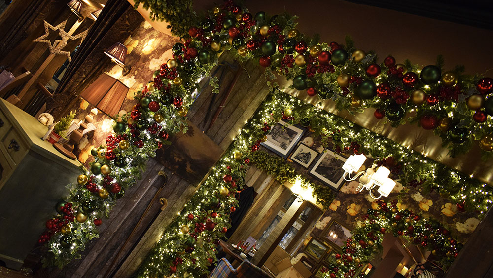 red, gold, green christmas decorations on garland archway inside the inn