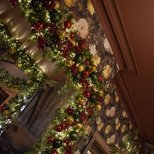 christmas decoration service inside pub - garland archway in red, gold and green 