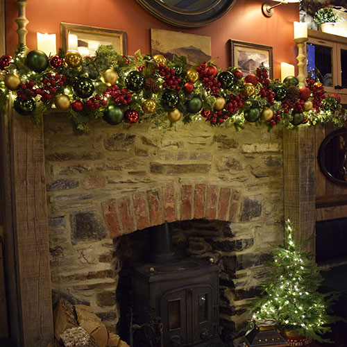pub fireplace with red, gold and green festive garland