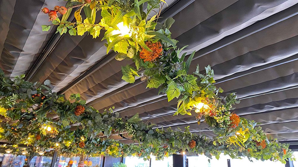 artificial vines and flowers installed on the bar's terrace framework