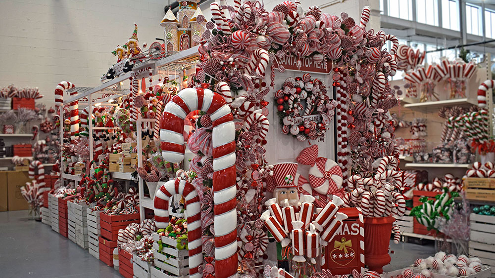red and white candy cane themed christmas decorations on display in store with giant candy cane ornaments