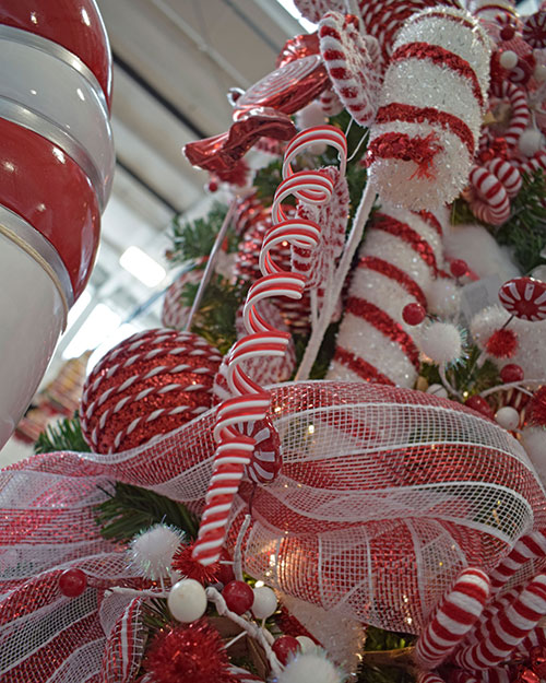 red and white spiral drop candy cane theme decoration on tree with striped deco mesh