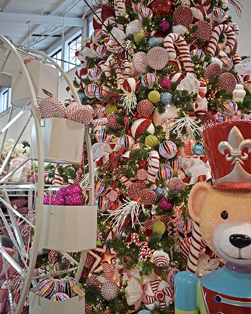 teddy bear nutcracker ornament, white ferris wheel display and large christmas tree with multicoloured baubles