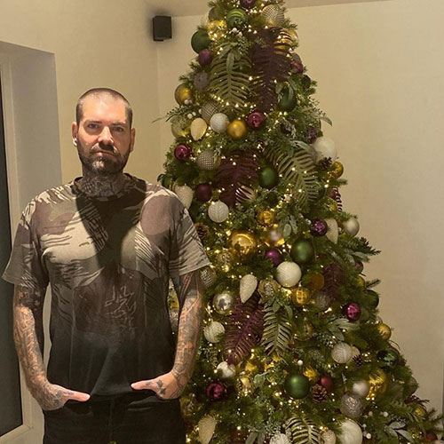 celebrity shane lynch stood in front of decorated christmas tree