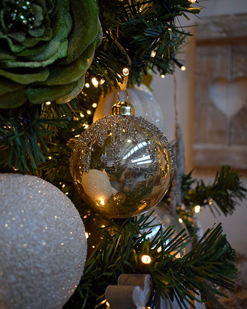 glittery cream and champagne baubles, with green velvet rose in green tree with fairy lights