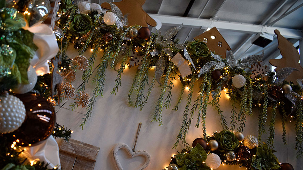 champagne christmas theme garland with hanging foliage, and brown, cream, green and champagne colour decorations