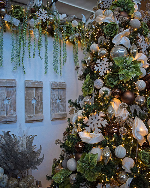 Champagne christmas theme tree with garland and three wooden star cut out panels on white wall