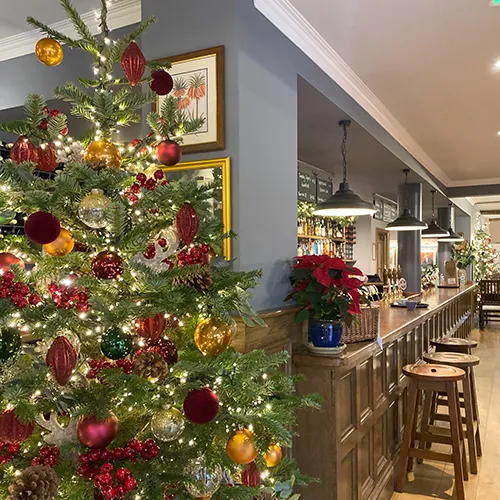 decorated christmas tree with fairy lights next to the bar in pub restaurant