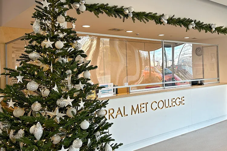 white, crystal, and silver decorated green christmas tree next to wirral met college reception desk