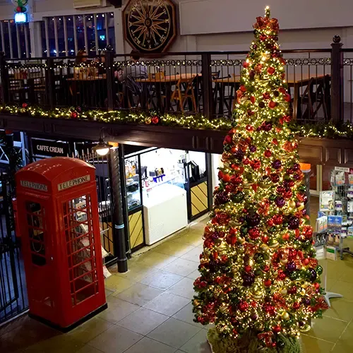 commercial space with large decorated christmas tree, balcony and telephone box