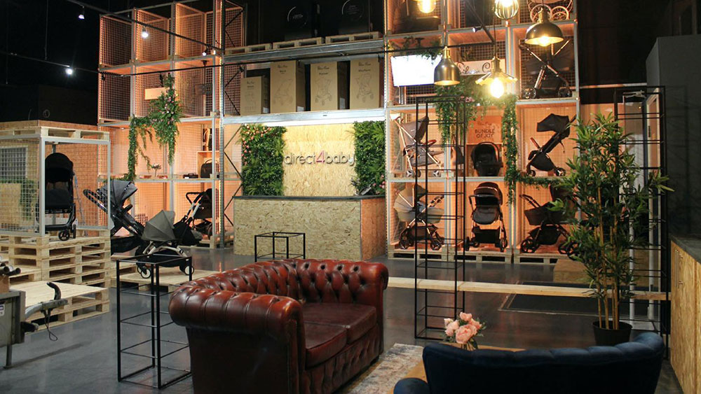 nursery retail interior design with industrial units, artificial foliage and trees, luxury sofas