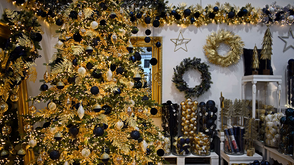 display of gold and blue christmas decorations with tree, wreaths, and garland