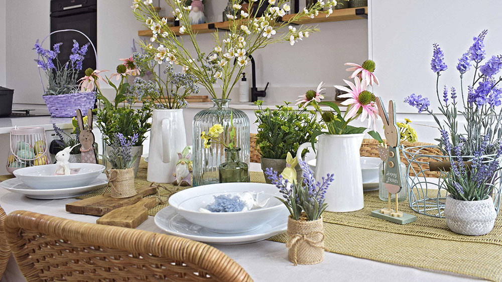 pastel easter decorations on table with artificial flowers and crockery