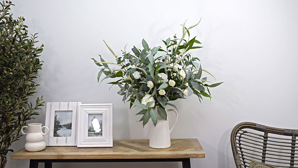 floral trend white and green artifical flower display in white vase on side table