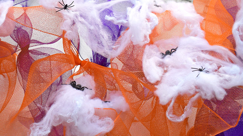 orange and purple deco mesh halloween decorations with cobweb and spiders