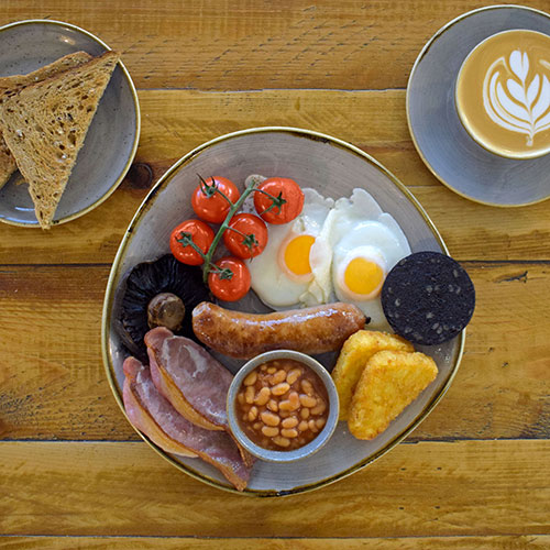 hearty fried breakfast with toast and coffee viewed from above