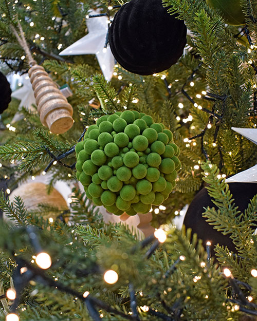 close up of cluster ball green fabric bauble hanging in nordic theme christmas tree