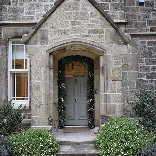 residential christmas decorating service - stone entrance porch with door arch garland