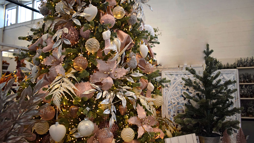 pink christmas decorations and white heart baubles on christmas tree with rose gold metallic faux leaves and ferns
