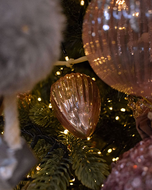 pink metallic ribbed teardrop bauble in Christmas tree with lights