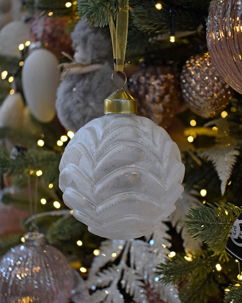 frosted white scallop design bauble hanging in pink themed christmas tree