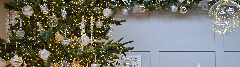 clear christmas decorations and baubles on green tree
