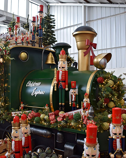 front of display steam train with nutcracker figures, pine garlands, and santas workshop theme decorations