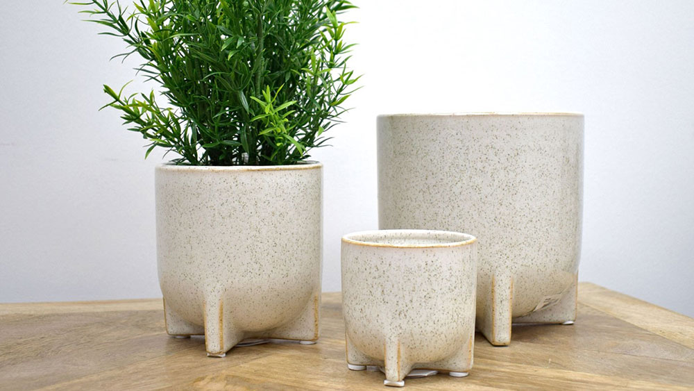 three speckled off-white stoneware pots in different sizes