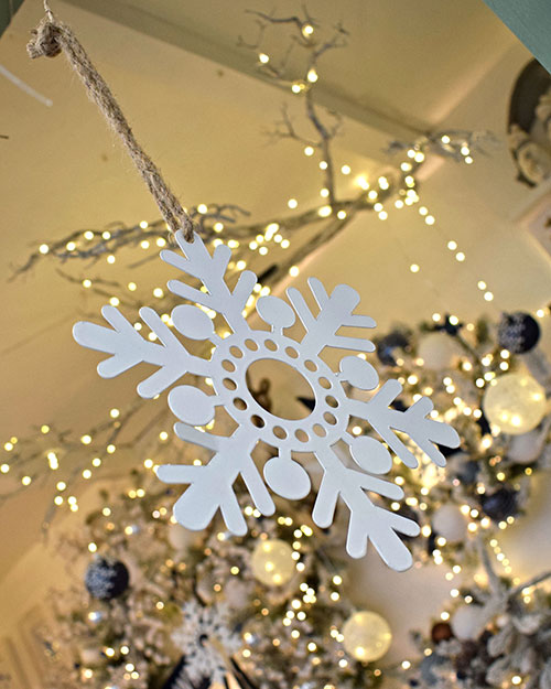 close up of white cut out snowflake christmas decoration on string
