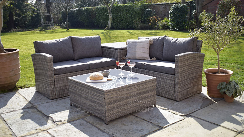 two grey rattan outdoor sofas with coffee table, drinks and bread
