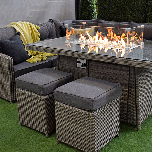 outdoor rattan fire pit dining table, stools, corner sofa and yellow throw