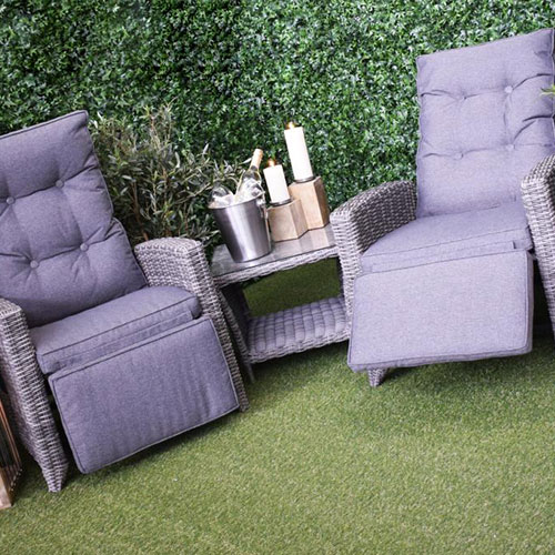 grey outdoor rattan recliner chairs with side table, candles and ice bucket