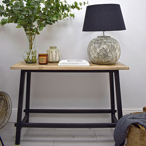 styling a console table with faux foliage, vase, candles, and lamp