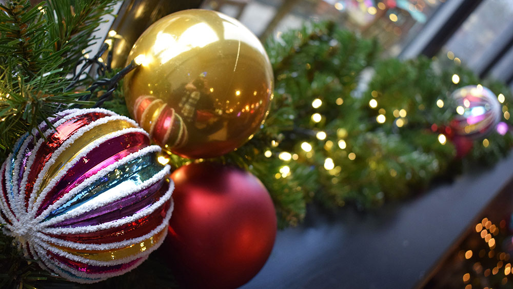 multicoloured bespoke bauble with gold and red bauble on green garland in hotel