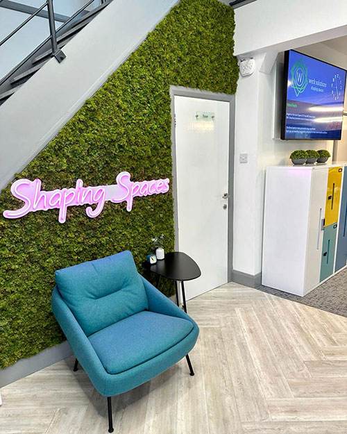 artificial moss wall with shaping spaces pink neon sign and turquoise chair