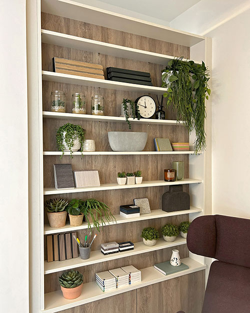 contemporary white shelving with various potted artificial plants and succulents