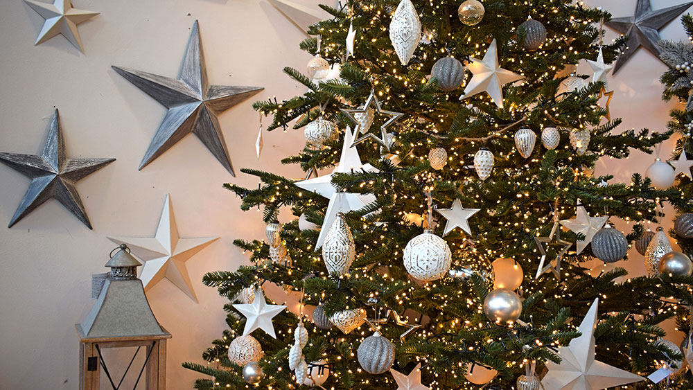 white christmas theme tree with white stars, patterned baubles and lantern