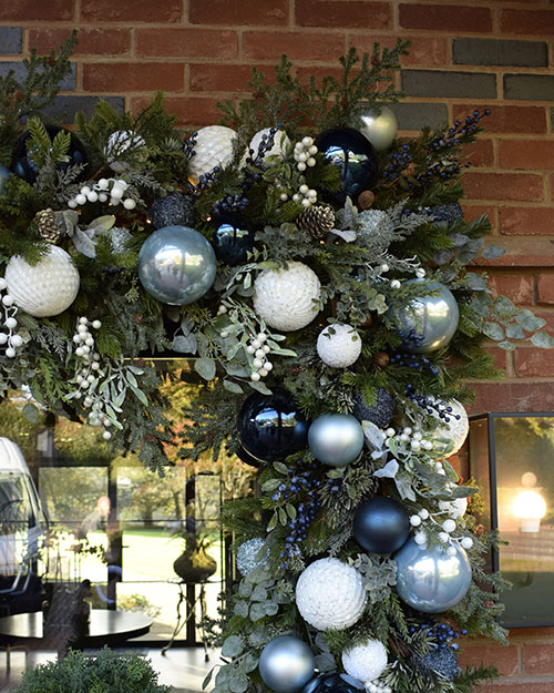 residential christmas decorating service - close up of door garland with faux foliage and white and blue berries